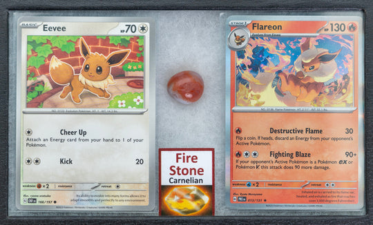 Two trading cards featuring Eevee and Flareon, a Fire Stone Carnelian gemstone, and a clear display case.