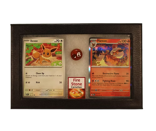 Two trading cards featuring Eevee and Flareon, a red crystal, and a card titled 'Fire Stone Carnelian' in a display case.