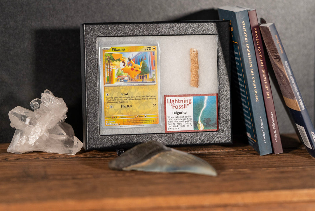 Framed collectible card with a crystal and books on a wooden surface