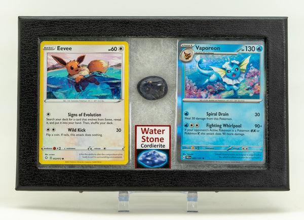 Two trading cards displayed in a frame with a stone underneath