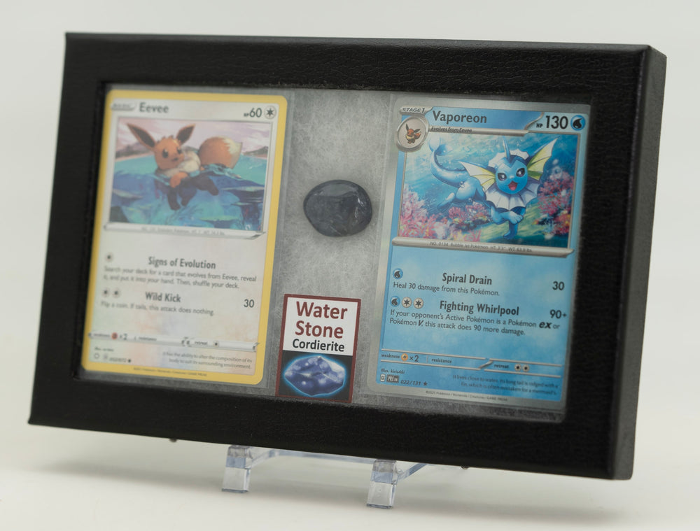 Framed display of two trading cards with a stone in the center on a white background