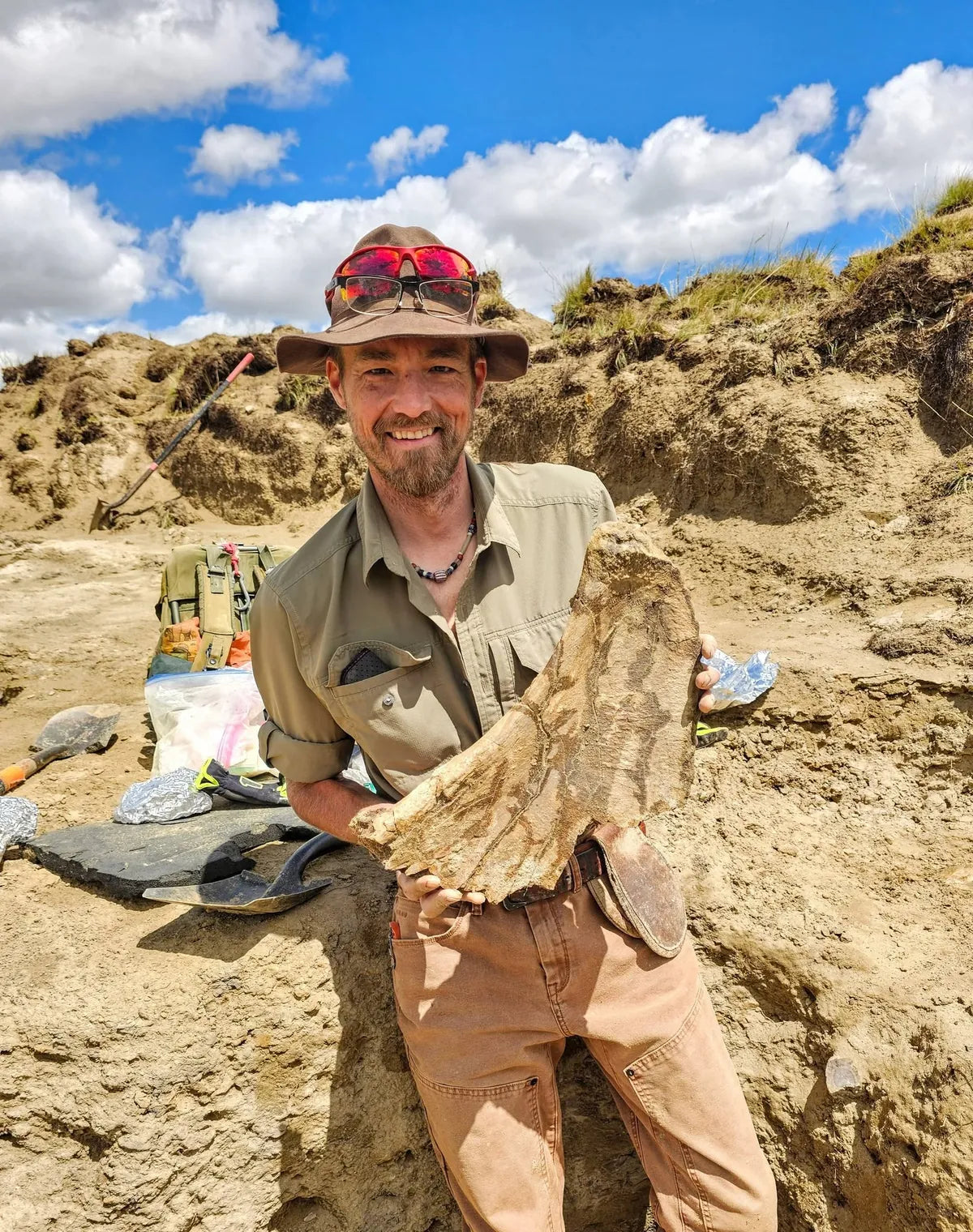 Chase Pipes holding a fossil discovery at a field excavation